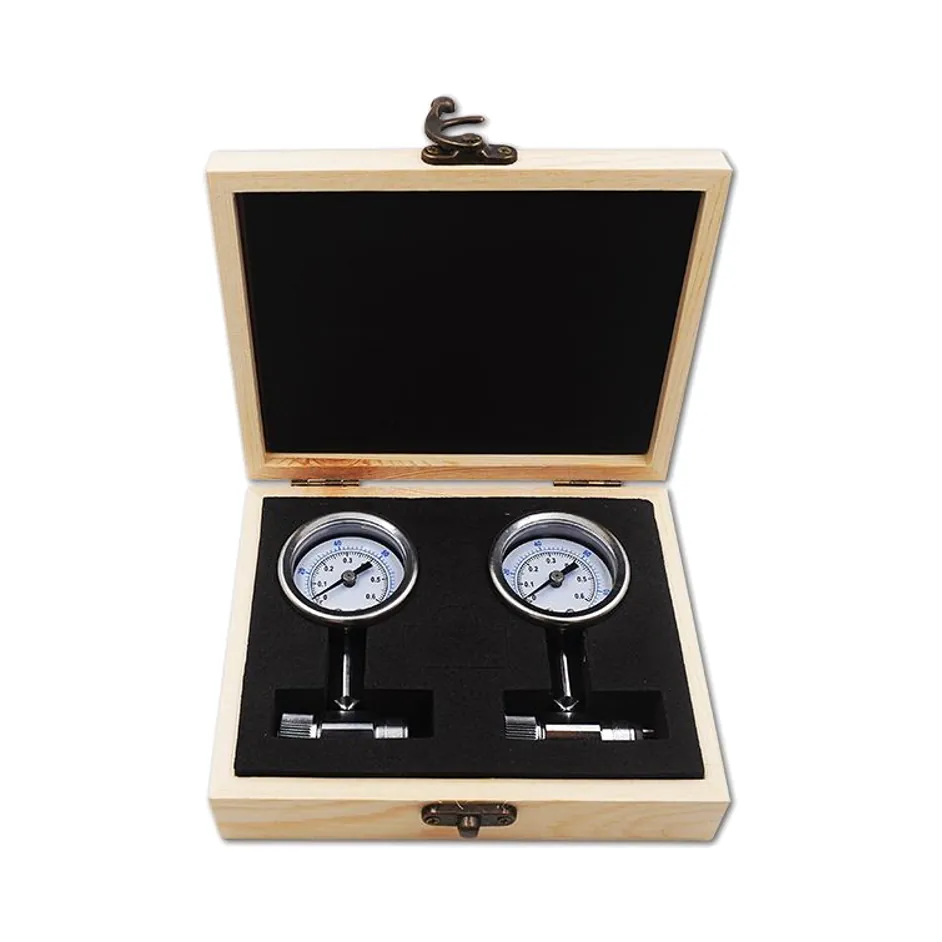 Two handpiece air-pressure test gauges in an open wooden box