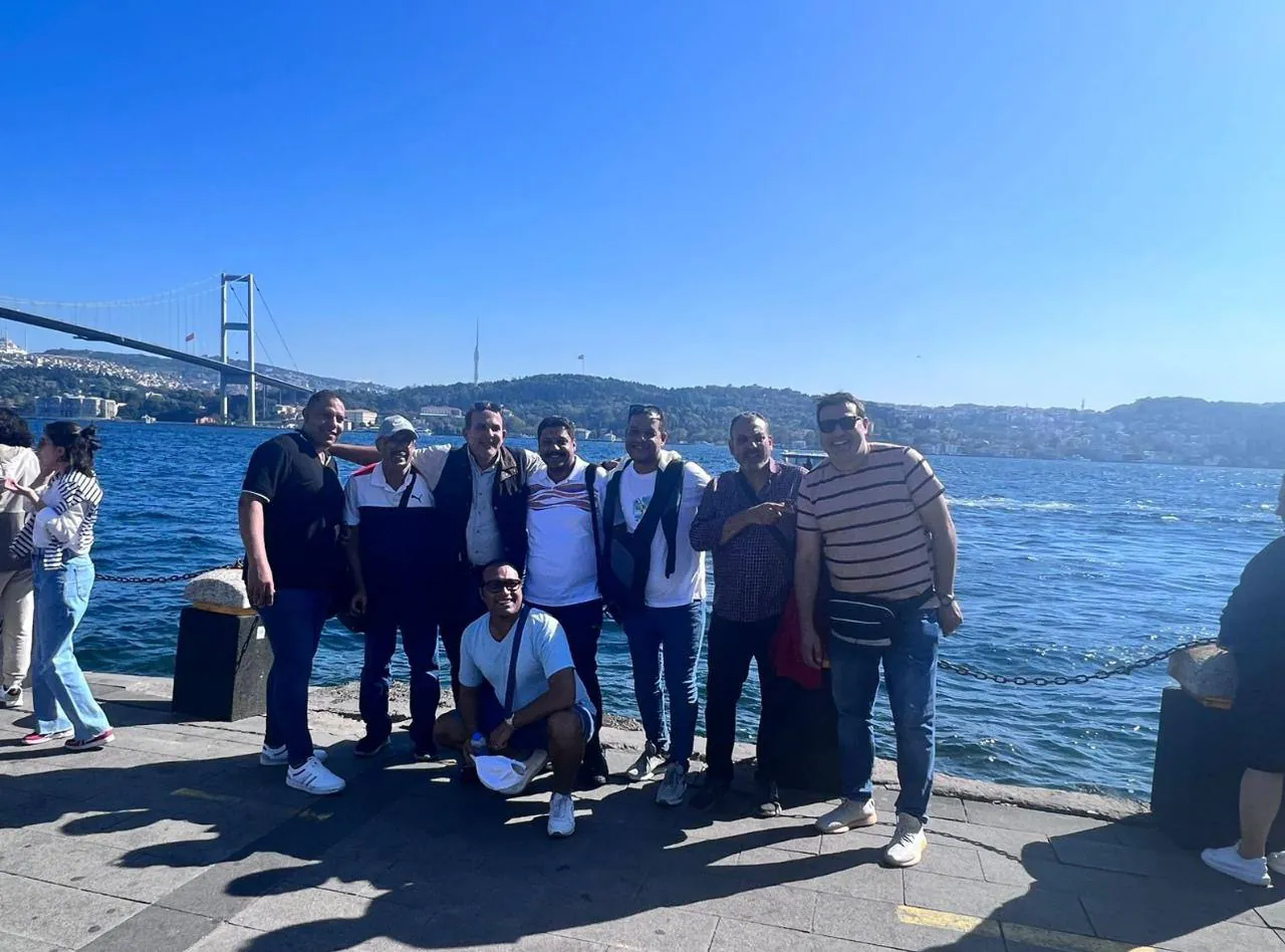 The group posing on the waterfront, with the Bosphorus Bridge behind them