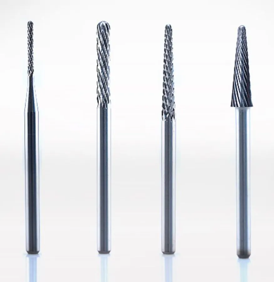 Four tungsten carbide milling burs standing upright
